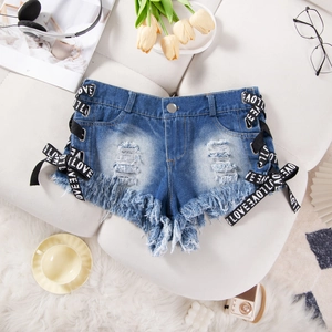 Dettaglio di pantaloncini di jeans blu con lacci laterali 'LOVE' e orli sfilacciati
