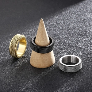 Mens stainless steel spinning rings in gold, black, and silver with knurled texture