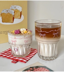 Detailed view of glass cups with pink bow patterns, featuring layered coffee and yogurt