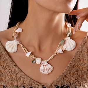 Detail view of woven raffia choker with natural shells and green accents for summer beach