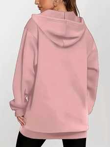 Back view of a pink oversized hooded sweatshirt with a casual loose fit and long hem