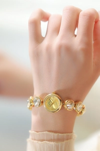 Détail d'une montre de luxe en or pour femme avec bracelet serti de strass brillants