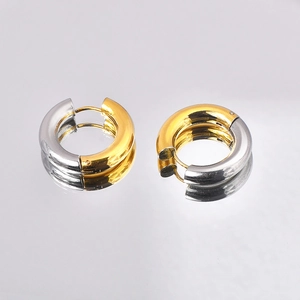 Close-up of two-tone gold and silver circular hoop earrings with polished finish