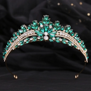 Macro detail of royal tiara featuring emerald green rhinestones and golden alloy frame