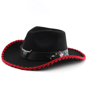 Detail of black cowboy hat with bull head ornament and red woven brim trim