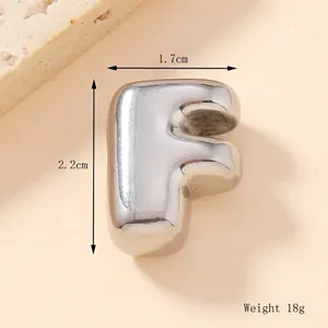 Macro view of silver stainless steel bubble letter F pendant with 1.7x2.2cm dimensions