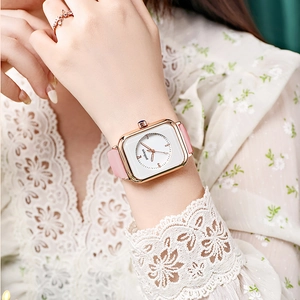 Close-up of a square rose gold quartz watch with a white dial and pink leather strap