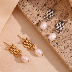 Detailed view of woven chain earrings with teardrop pearls on silk and stone