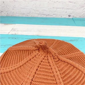 Detailed macro view of the caramel orange knitted beret with thick ribbed texture
