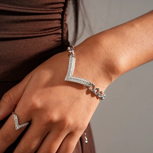 Macro detail of silver V-shaped bracelet and ring set with crystal-encrusted metal links