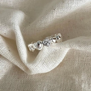 Polished S925 silver heart ring featuring a central sparkling heart-cut zircon stone