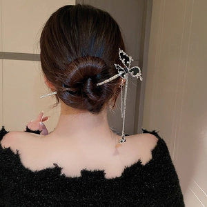 Detailed view of silver butterfly hair pin with sparkling rhinestones and long tassels