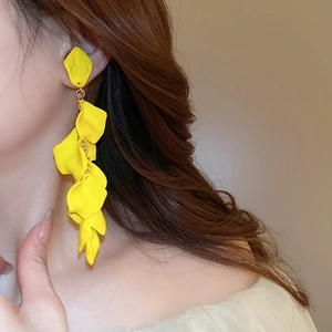 Detailed close-up of a model wearing yellow rose petal long tassel clip-on earrings