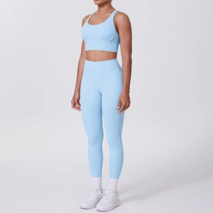 Détail d'un ensemble de yoga bleu clair avec brassière croisée et legging taille haute