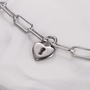 Detailed macro view of silver heart lock pendant and paperclip link chain necklace