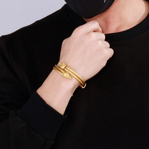Viking style double wolf head twisted rope bracelet in gold finish worn on male wrist