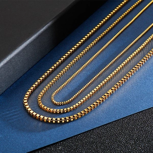 Three gold stainless steel box chains in different thicknesses displayed on a gift box