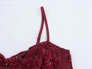 Detail of burgundy lace dress with floral embroidery, sequins and adjustable strap
