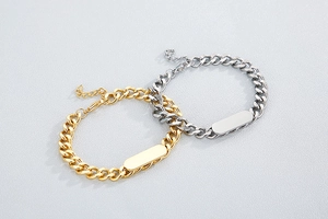 Close-up of gold and silver stainless steel Cuban link nameplate bracelets