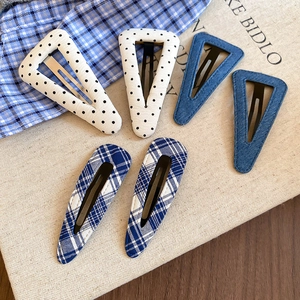 Dettaglio del set di 6 fermagli in tessuto con pois, denim e motivi a quadretti