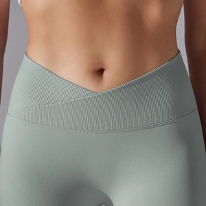 Detail of high-waist cross-waist design and ribbed texture on green seamless yoga leggings