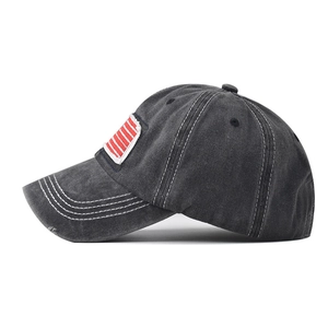 Detail of washed cotton baseball cap with American flag embroidery and distressed brim