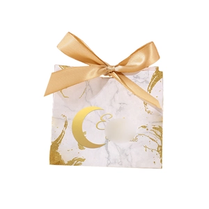 Detailed close-up of marble pattern gift box with golden Eid Mubarak text and ribbon
