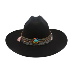 Détail d'un chapeau en denim noir avec perles ethniques, turquoise et pompons décoratifs