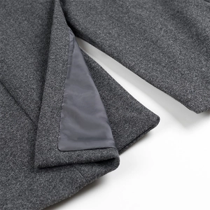 Macro detail of dark grey wool coat hem showing high-quality inner lining and fiber texture