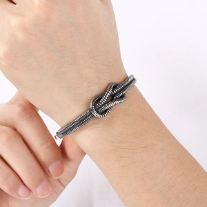 Macro detail of silver knot bracelet with vintage oxidized finish and twisted rope design