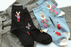 Detail of embroidered forest rabbit patterns on cotton crew socks in black and light blue