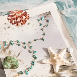 Artistic layout of turquoise stone necklace with seashell and starfish beach decor