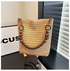 Close-up of khaki straw bucket bag with brown PU strap and decorative wooden beads