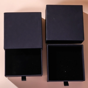 Detail view of a black drawer-style jewelry gift box with velvet insert for rings and necklaces
