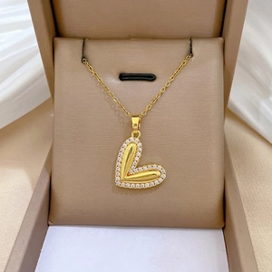 Elegant gold heart pendant necklace with shimmering pave zircons on velvet display