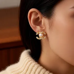 14k gold plated pearl flower earrings with elegant double C crystal design on model