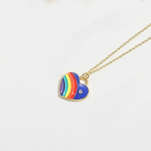 Close-up of a rainbow and blue enamel heart pendant with a small rhinestone on a gold chain