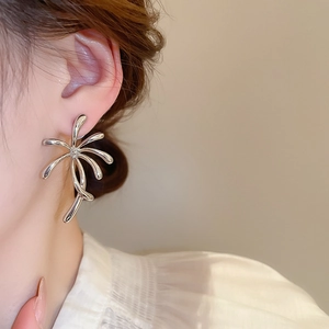 Close-up of silver flower stud earrings with crystals on a woman's ear