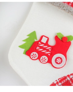 Close-up of white knitted Christmas stocking with faux fur and train felt applique