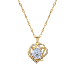 Double layered gold heart pendant necklace with shimmering crystals and a center gemstone