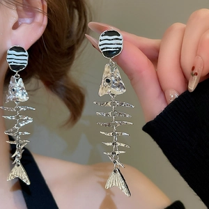 Detailed view of silver fishbone drop earrings with unique geometric jointed metal texture