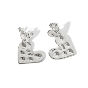 Detail of silver hammered heart drop earrings with unique textured finish and metal shine