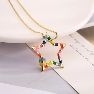 Detalle macro del colgante de estrella en esmalte arcoíris con cadena de oro fina