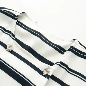 Detail of silver irregular metal buttons and striped fabric texture on the collar and placket