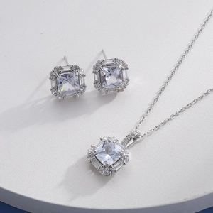 Silver necklace and earring set with square halo-set zircons on white platform