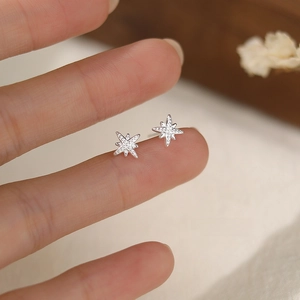 S999 pure silver star stud earrings held on fingertip showing minimalist mini size
