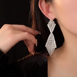 Elegante silberne Quasten-Ohrringe mit glitzernden Strasssteinen am Ohr getragen