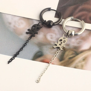 Macro detail of black and silver stainless steel skull earrings with long chain pendants