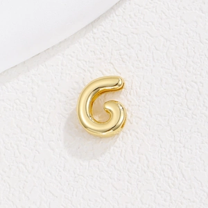 Makroaufnahme von 3D Goldbuchstabe G Anhänger mit glänzendem Finish und minimalistischem Stil