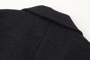 Detailed close-up of dark grey wool coat lapel showcasing high-quality fabric texture